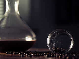 Filter pour-over coffee, made from raw coffee beans and hot water, portrait of a coffee drink with smoke and fumes on a wooden table