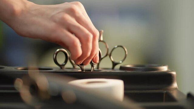 A barber's hand takes scissors for a haircut
