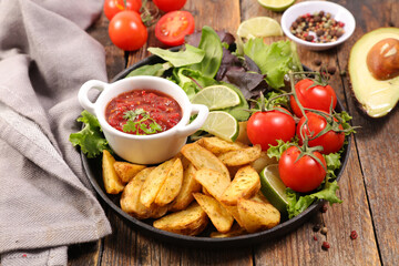 fried potatoes wedges tomato spicy sauce and vegetables