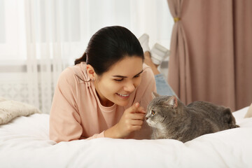 Young woman with adorable cat at home