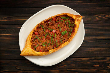 Savory meat pide on a white plate with traditional Turkish spices