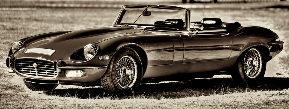 Panoramic shot of a Jaguar E-Type Convertible HDR Black on the grass outdoors