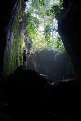 Silhouette of man standing in the dark cave, Thailand.