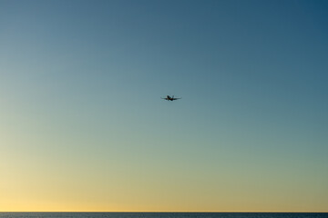 Airplane landing at sunrise over Mediterranean Sea, Costa del Sol in Malaga, Spain on March 25, 2023