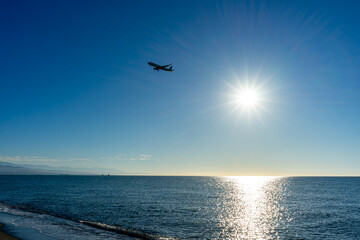 Airplane landing at sunrise over Mediterranean Sea, Costa del Sol in Malaga, Spain on March 25, 2023