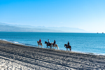 Riders on Mediterranean Sea at sunrise, Costa del Sol in Malaga, Spain on March 25, 2023
