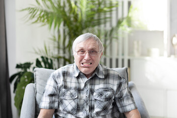 Portrait of Funny retired man with denture looking at the camera and smiling