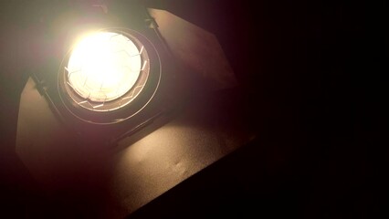Video studio Fresnel lens spotlight on black background. lights slowly turn on and off.