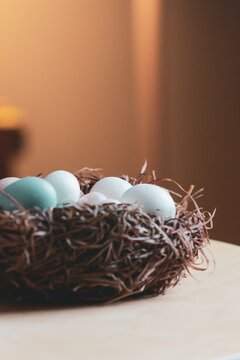 Vertical closeup shot of colorful Easter eggs in a nest on table