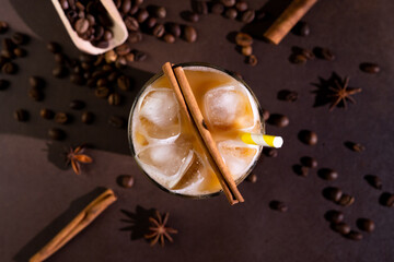 Top view of a Cappuccino with Ice cubes in a tall Glass against a black background. Iced Coffee...
