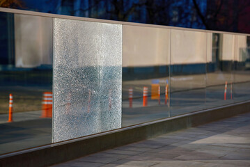 Damaged tempered glass fence. Broken glass fence with banisters. Broken guard rail on office...