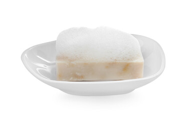 Soap bar with fluffy foam in holder on white background