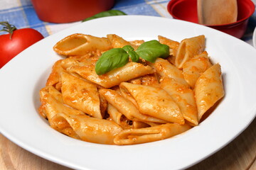 Delicious Italian pasta dish with tuna sauce, onion, tomato and fresh basil pesto.