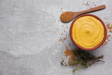 Bowl with delicious mustard, seeds and dry thyme on light grey table, flat lay. Space for text