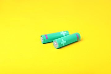 New AA size batteries on yellow background