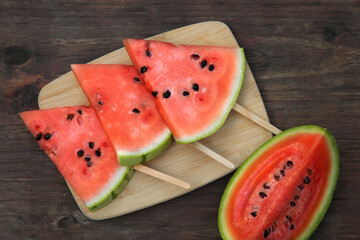 Cut delicious ripe watermelon on wooden table, flat lay