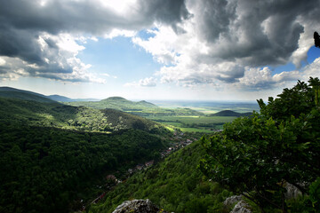 Panoramic view of  beautifully green covered hills and fields under a cloudy sky
