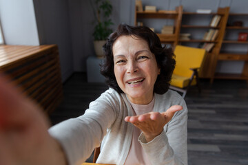 Happy middle aged senior woman talk on video call with friends family. Laughing mature old senior grandmother having fun speaking with grown up children online. Headshot portrait selfie webcamera view