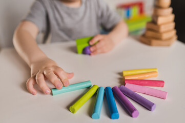 Child hands playing with colorful clay. Homemade plastiline. play dough. Boy molding modeling rainbow clay. 