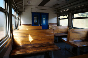 Old empty wagon of train. Wooden seats in an empty coach of train