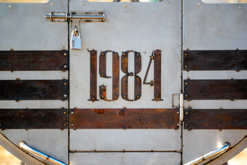 A steel door with a lock and 1984 number written on it