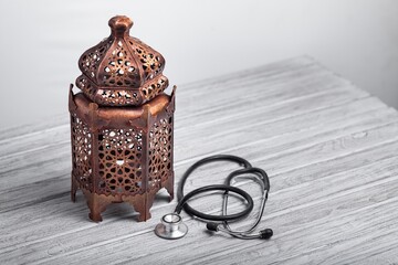 Ramadan Islamic lantern and a stethoscope on desk. Medical concept