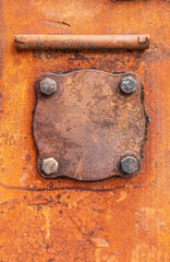 Rusty metal surface with cap and bolts, free space for text. Steel cover on the outside of an armored vehicle