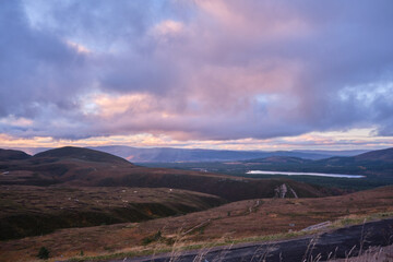 Beautiful view of a mountain river under overcast sky at sunset in Scotland