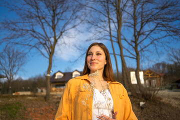 Portrait image of a happy woman standing in park, weekend acitivities.
