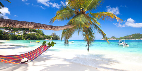 Fototapeta na wymiar tropischer Strand mit Palmen und Hängematte
