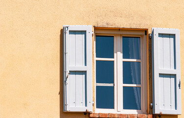 Fototapeta na wymiar Front view, medium distance of, a pair of, tall, blue, wood, open, window shutters