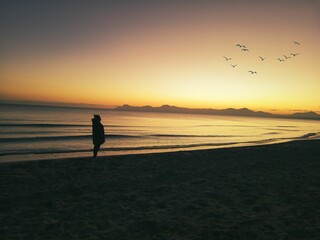 hombre al amenecer el la playa