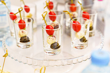 canapes with cherry tomato, mozzarella and olive in cups 