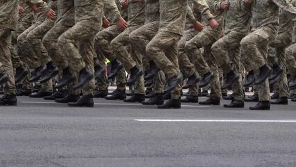 Many legs go in a row. Military uniform. A company of soldiers marching in a parade. Soldier boots. Pixel shape protective khaki clothing. Men go march. Airborne forces. Army crowd. Force man