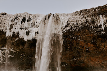 Fototapeta na wymiar Winter raw landscapes in Iceland. The waterfall in a background