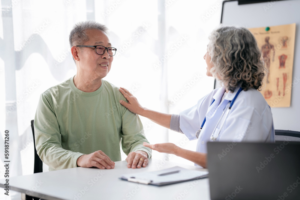 Wall mural Female doctor touching shoulder to encourage senior patient and