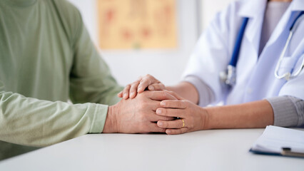 Female doctor holding hands to encourage senior patient and expl