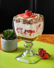 Vertical closeup shot of yogurt with oatmeal and strawberry served in a cup for breakfast