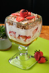 Vertical closeup shot of yogurt with oatmeal and strawberry served in a cup for breakfast