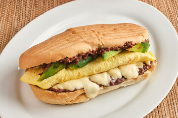 Closeup shot of panini with cheese, eggs, avocados and fried beans
