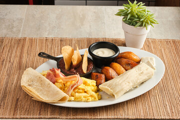 Closeup shot of a traditional breakfast with tortilla, fried plantains, eggs and bacon