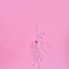 Crystal glass ballerina figure isolated on a pink background