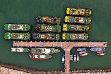 Seaport aerial view with moored tug boats.