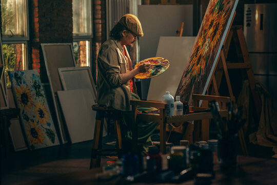 The artist paints seriously in the studio