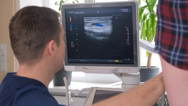 The doctor diagnoses the veins on the legs with the help of ultrasound diagnostics. 