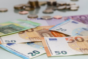 Shallow focus shot of euro banknotes with blurred coins i the background