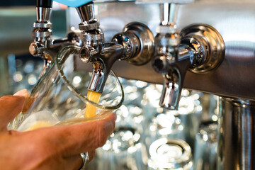 Golden Draft Beer Freshly Poured from Bar Taps with Bubbles and Foam