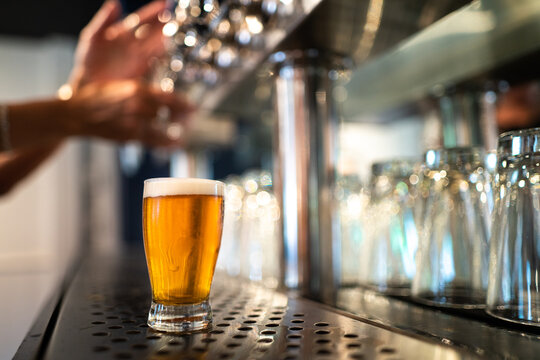 Fresh poured frothy draft beer in a near bar taps