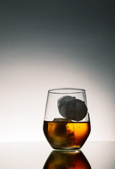 Iced Alcohol drink in a glass cup with reflection on a mirror surface