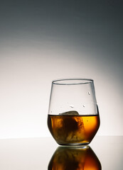 Iced Alcohol drink in a glass cup with reflection on a mirror surface